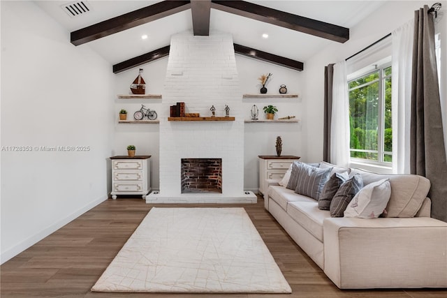 living room with vaulted ceiling with beams, dark hardwood / wood-style floors, and a brick fireplace