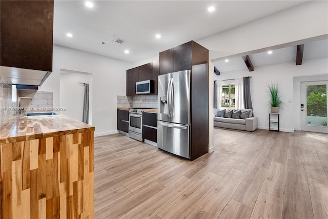 kitchen featuring a healthy amount of sunlight, stainless steel appliances, light hardwood / wood-style flooring, and backsplash