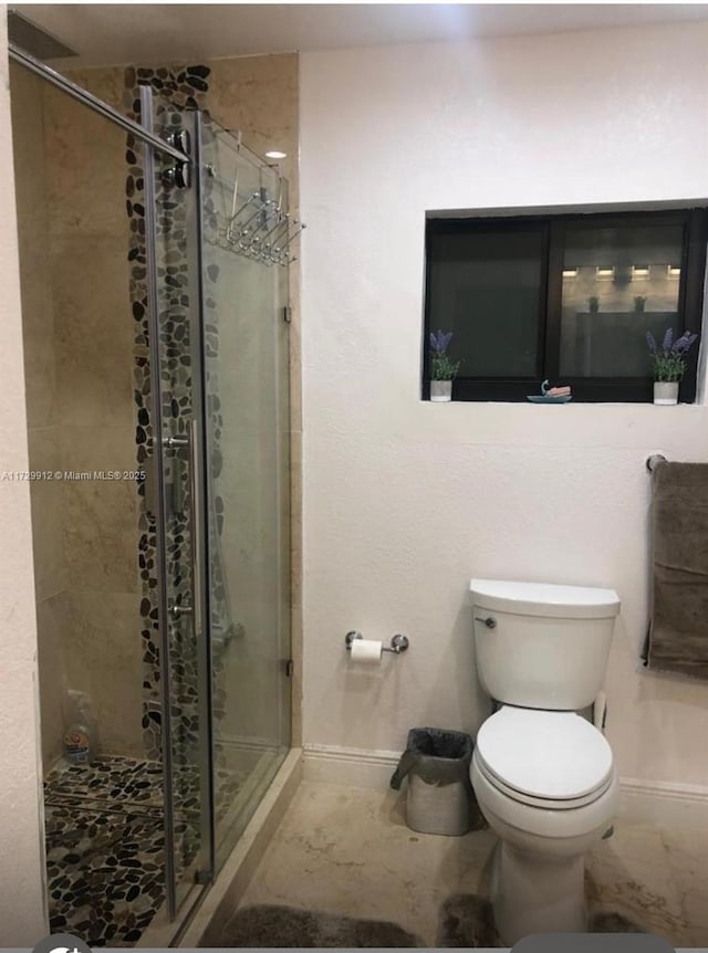 bathroom featuring walk in shower and toilet