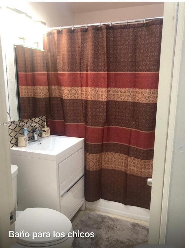 bathroom featuring vanity, toilet, and a shower with shower curtain