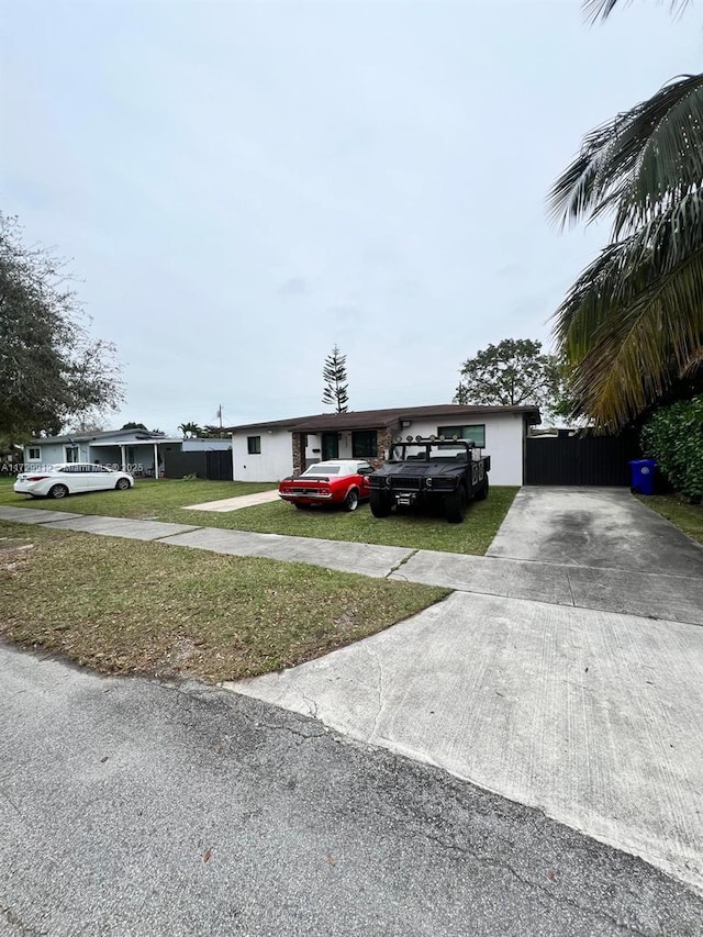 ranch-style home featuring a front lawn and a carport