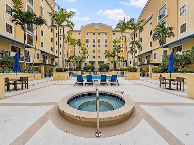 view of swimming pool featuring a patio and a hot tub