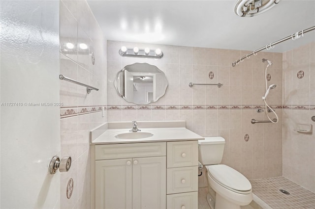 bathroom featuring tile walls, vanity, toilet, and tiled shower