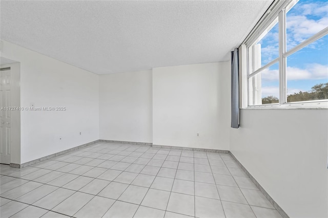 empty room with light tile patterned floors and a textured ceiling