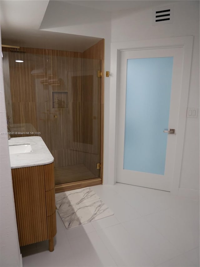 bathroom featuring an enclosed shower, vanity, and tile patterned flooring