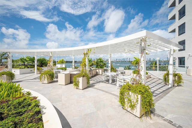 view of property's community featuring a patio, a water view, and a pergola