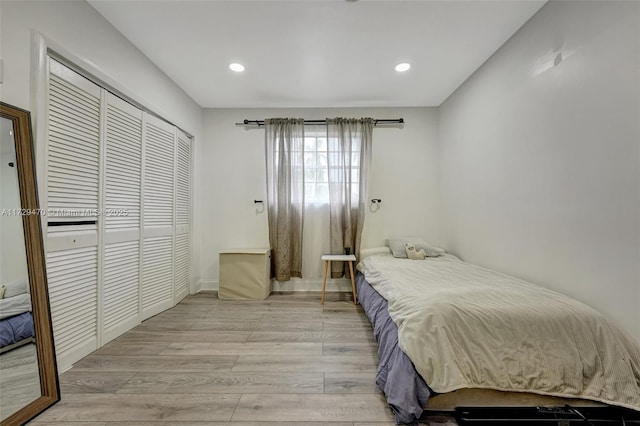 bedroom with light hardwood / wood-style floors and a closet