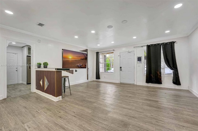 interior space featuring crown molding and light hardwood / wood-style flooring