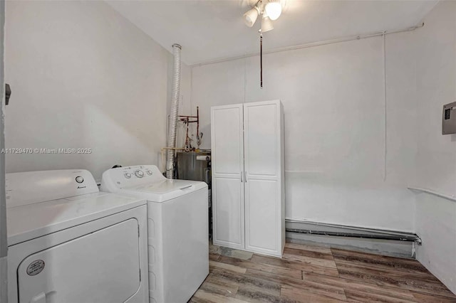 laundry room with light wood-type flooring, washer and clothes dryer, and cabinets