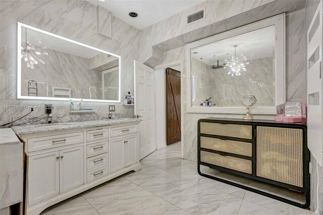 bathroom featuring vanity, a chandelier, and tile walls