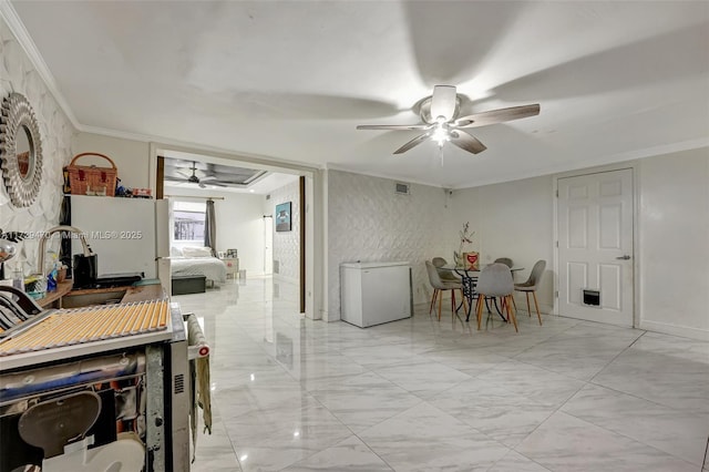 dining room featuring sink, ceiling fan, and ornamental molding