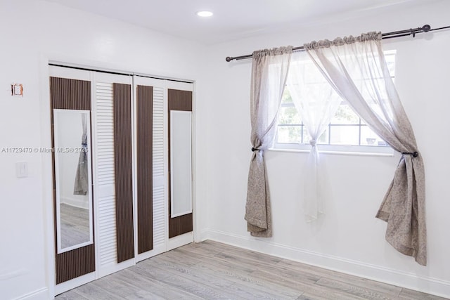 unfurnished bedroom featuring a closet and light hardwood / wood-style flooring