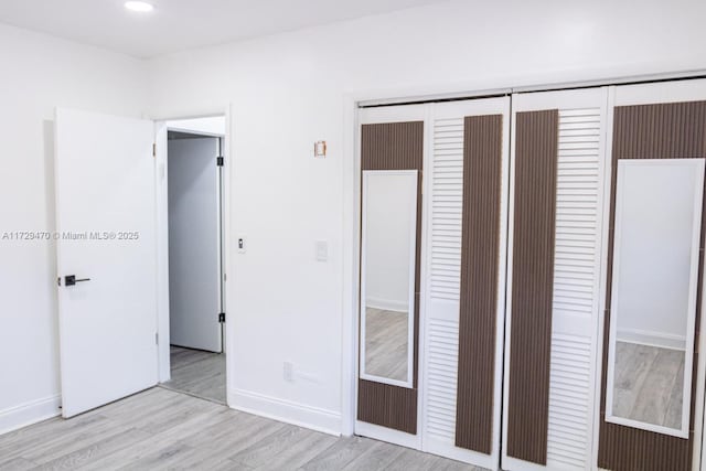 unfurnished bedroom featuring light hardwood / wood-style flooring and a closet