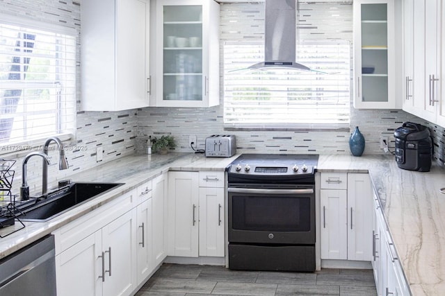 kitchen featuring sink, white cabinets, stainless steel appliances, and wall chimney exhaust hood