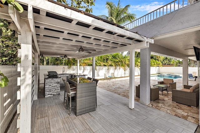 wooden terrace with area for grilling, an outdoor bar, a fenced in pool, ceiling fan, and an outdoor hangout area