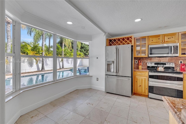 kitchen with ornamental molding, appliances with stainless steel finishes, tasteful backsplash, and a textured ceiling