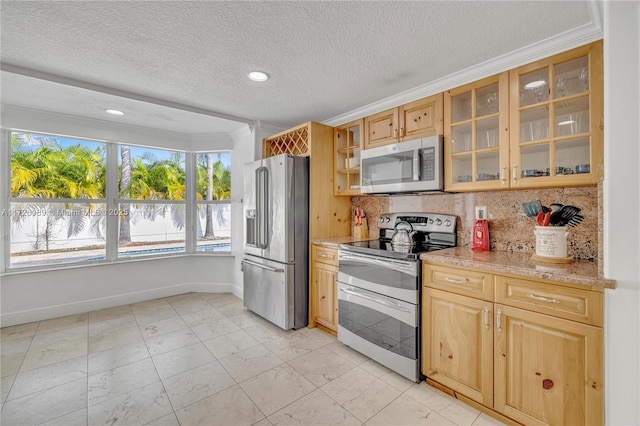 kitchen with crown molding, light stone counters, a textured ceiling, decorative backsplash, and stainless steel appliances