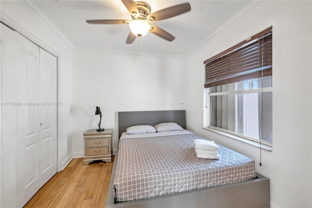 bedroom with a closet, ceiling fan, light hardwood / wood-style flooring, and crown molding