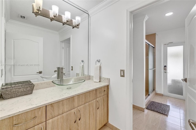 bathroom featuring a shower with shower door, vanity, ornamental molding, and tile patterned flooring