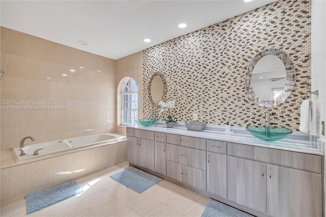 bathroom featuring tiled bath, tile walls, tile patterned floors, and vanity