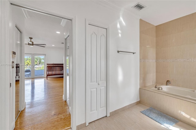 bathroom featuring crown molding, tiled bath, french doors, tile patterned floors, and ceiling fan