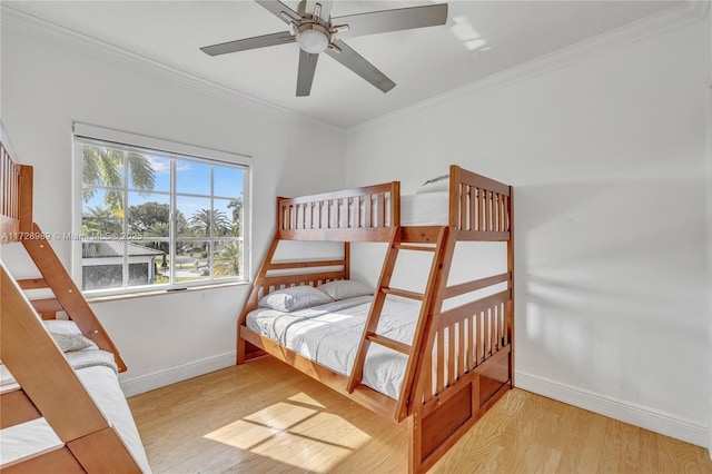 bedroom featuring multiple windows, light wood-type flooring, ceiling fan, and ornamental molding