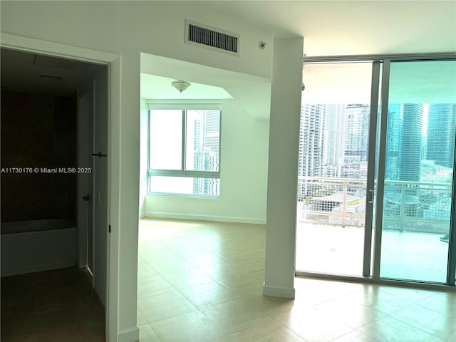 unfurnished room with baseboards, visible vents, and tile patterned flooring