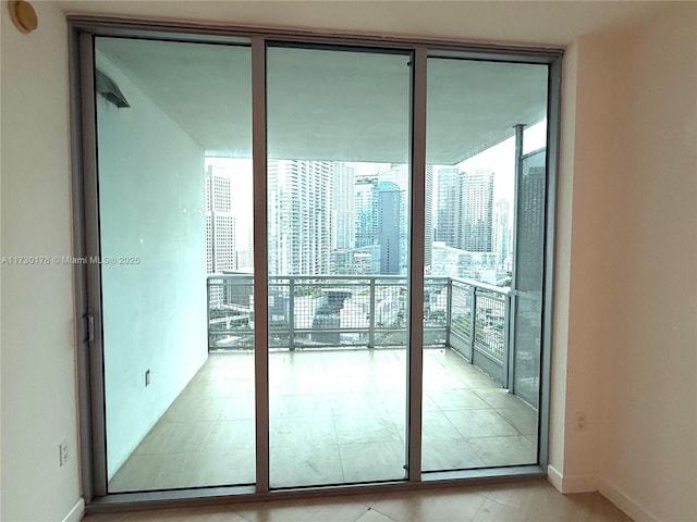 doorway to outside featuring baseboards, a wealth of natural light, and floor to ceiling windows