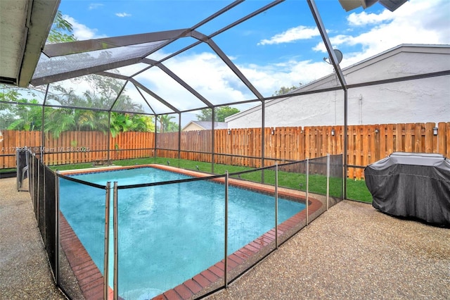 view of pool with glass enclosure and a patio