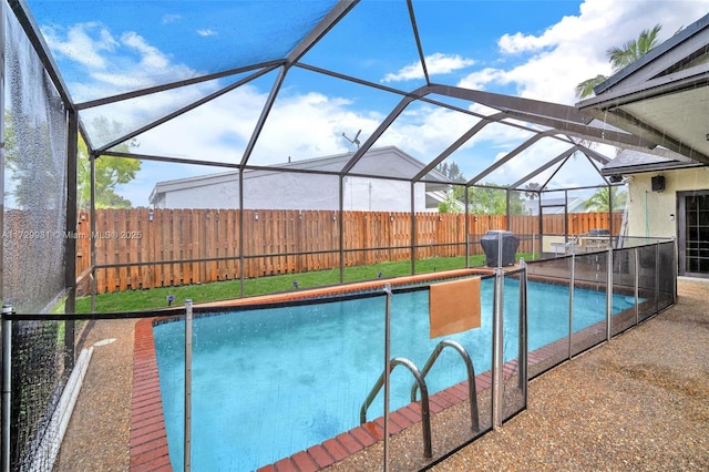 view of pool with glass enclosure and a patio area