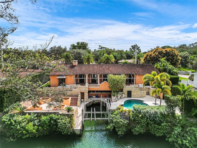 back of property featuring a patio area and a water view