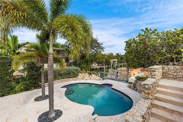 view of swimming pool featuring a patio area and a water view