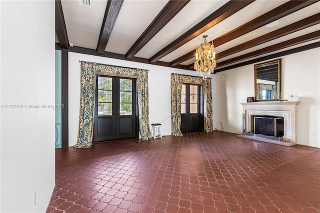 unfurnished living room featuring an inviting chandelier, beam ceiling, a high end fireplace, and french doors