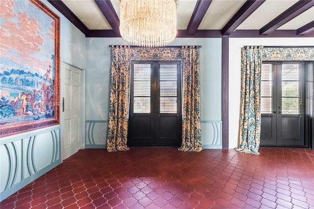 entrance foyer featuring beam ceiling, french doors, and an inviting chandelier