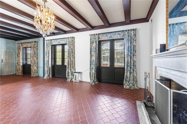 entrance foyer with a chandelier, beamed ceiling, and french doors