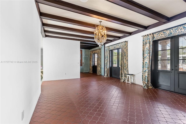 spare room featuring a healthy amount of sunlight, beamed ceiling, a notable chandelier, and french doors