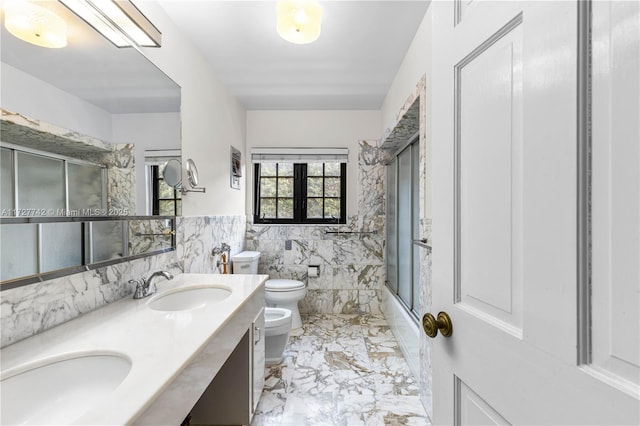 full bathroom with a bidet, toilet, tile walls, shower / bath combination with glass door, and vanity