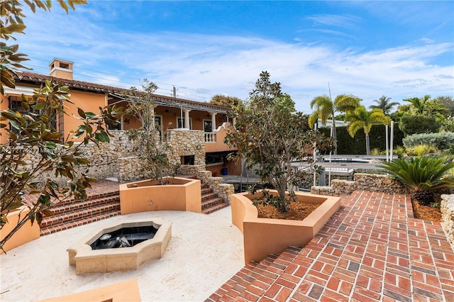 surrounding community featuring a patio area and a fire pit