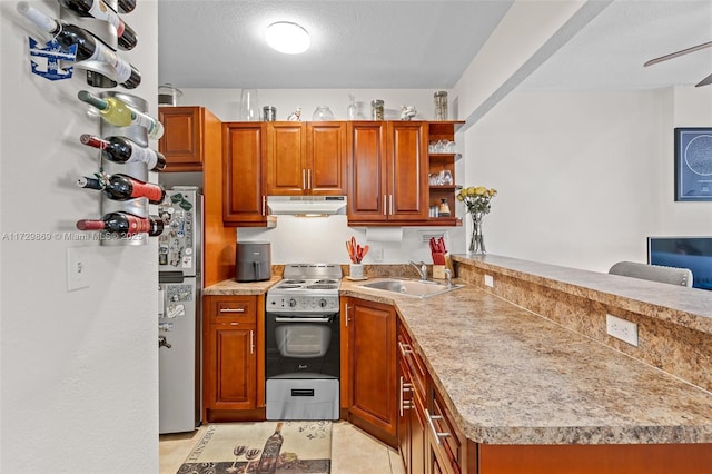 kitchen with appliances with stainless steel finishes, a textured ceiling, light tile patterned floors, sink, and kitchen peninsula