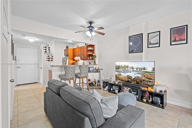 tiled living room featuring ceiling fan and a textured ceiling