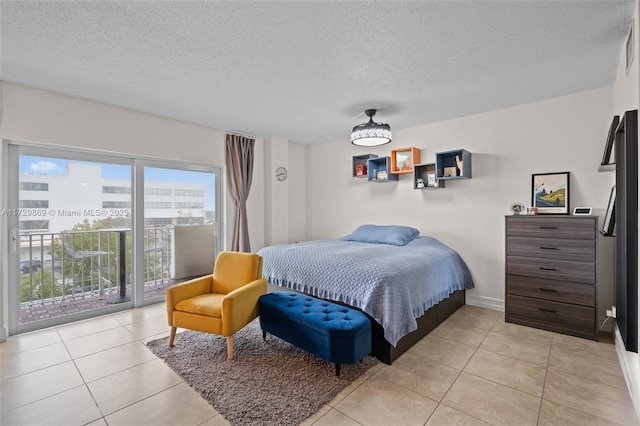 bedroom with access to outside, light tile patterned floors, and a textured ceiling