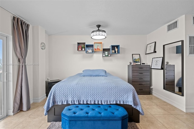 bedroom featuring light tile patterned flooring and a textured ceiling