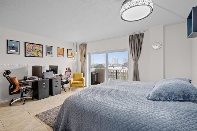 bedroom featuring a textured ceiling, light tile patterned floors, and access to outside