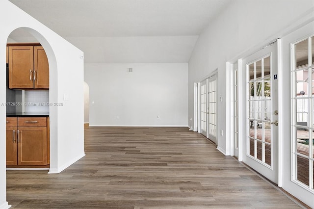 interior space with lofted ceiling and hardwood / wood-style floors