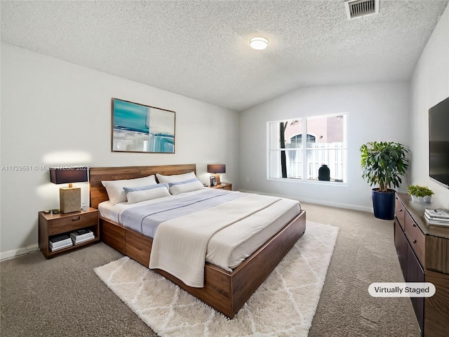 bedroom with lofted ceiling, light colored carpet, and a textured ceiling