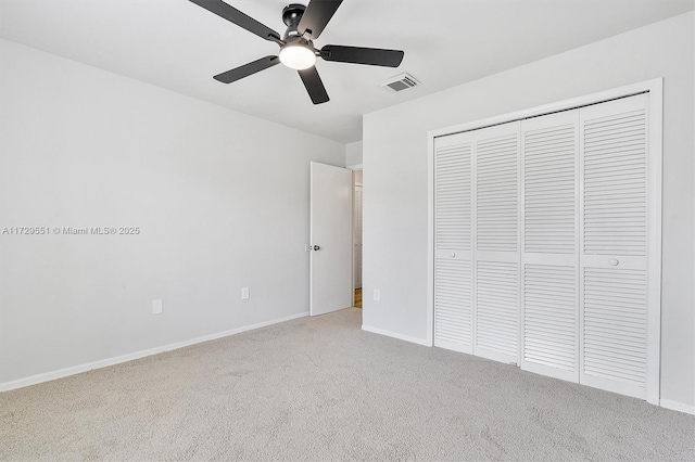 unfurnished bedroom with light carpet, a closet, and ceiling fan