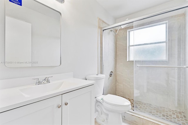 bathroom with vanity, a shower with shower door, and toilet