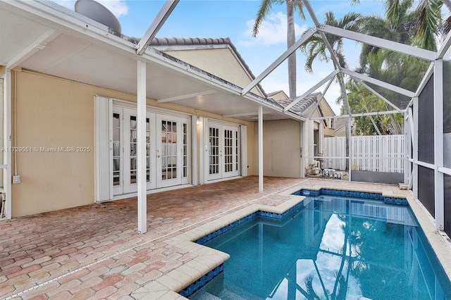 view of swimming pool with french doors, a lanai, and a patio