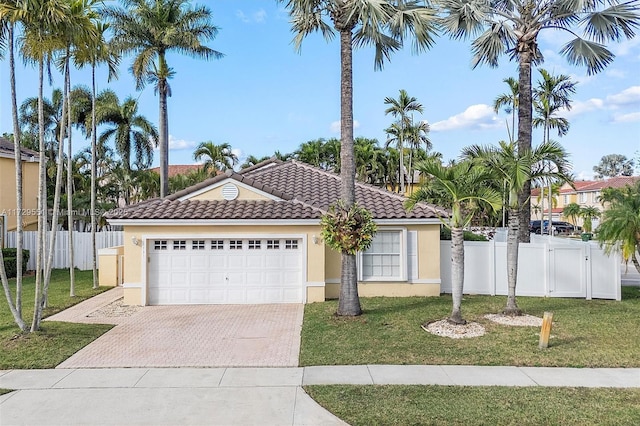 mediterranean / spanish house with a garage and a front lawn