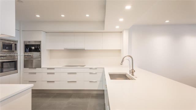 kitchen featuring sink, white cabinets, range hood, and appliances with stainless steel finishes